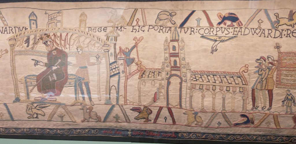 Reading museum's copy of the Bayeaux tapestry showing King Edward in the Palace, the new Westminster Abbey and Edward's funeral procession.