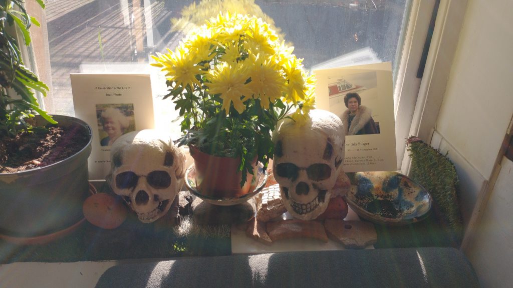 Picture of window sill with skulls, Chrysanthemums  and pictures of remembrance