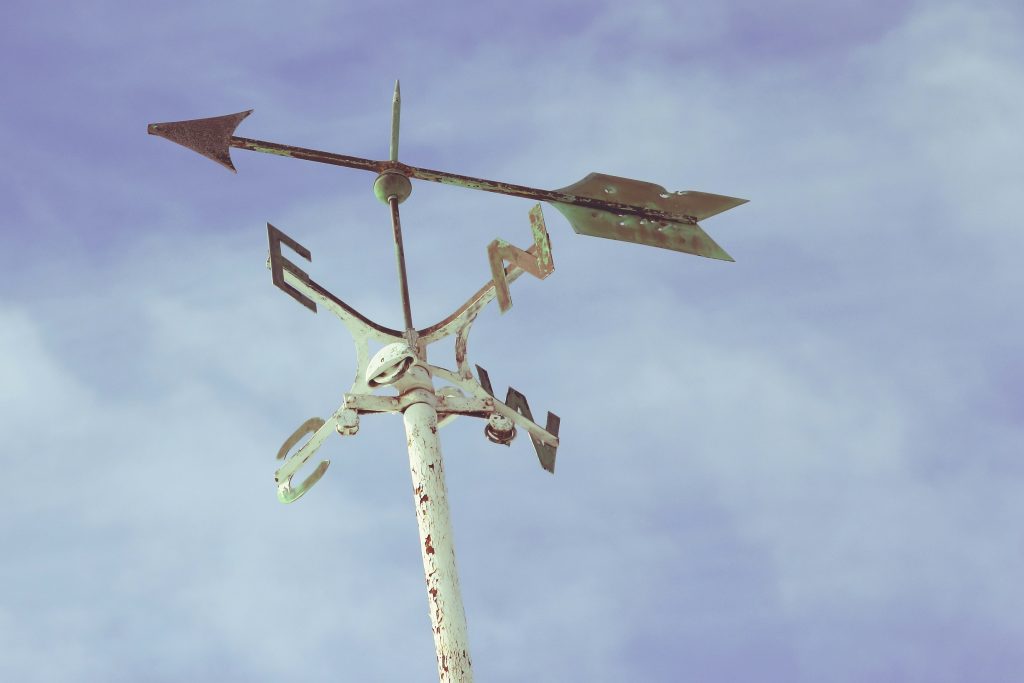 Photo  by Jordan Ladikos on Unsplash of a weather vane showing the cardinal points